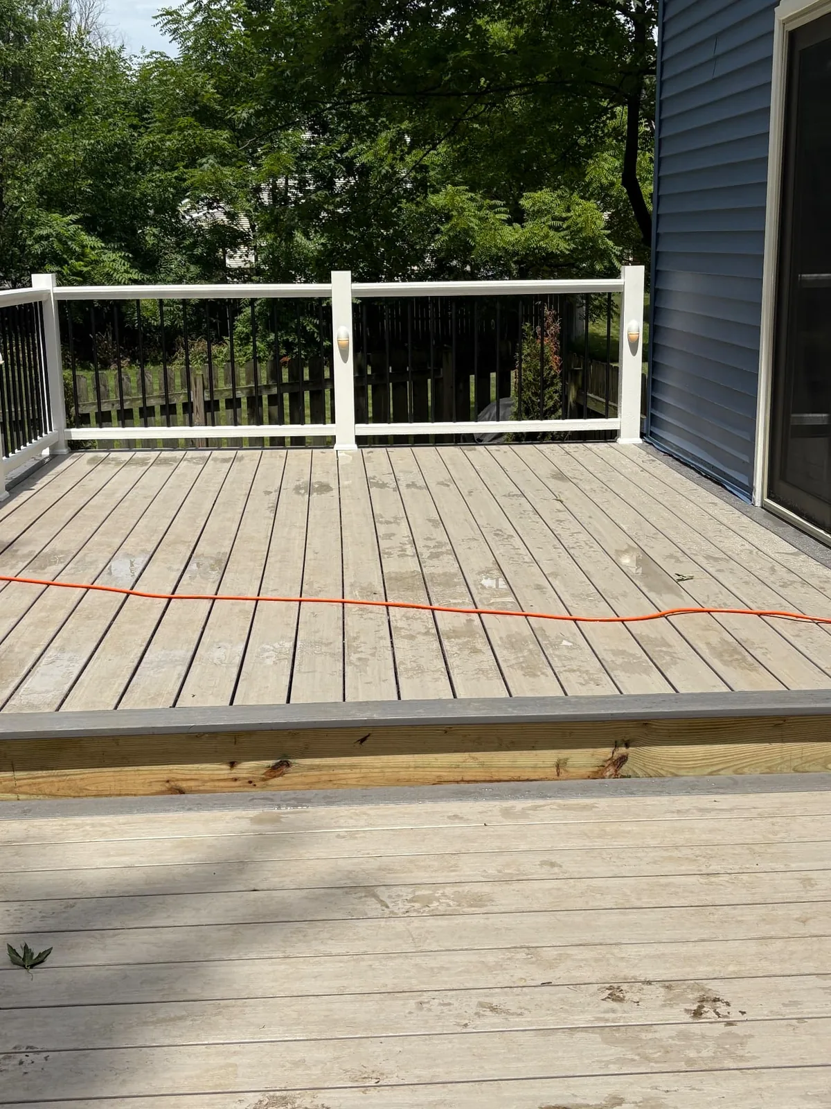 Light composite deck surface with white and black railing