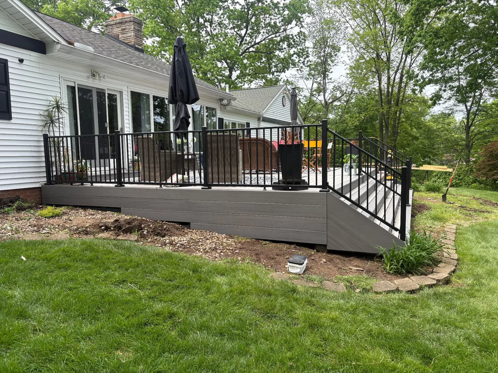 Finished low composite deck with dark metal railings and steps