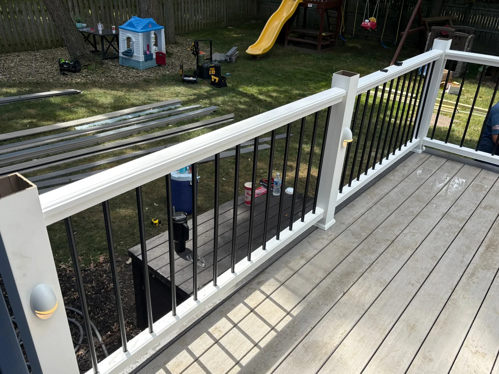Finished white and black railing along a light composite deck